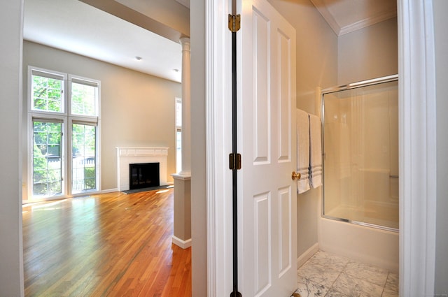 full bathroom featuring enclosed tub / shower combo, ornamental molding, a fireplace with flush hearth, and baseboards