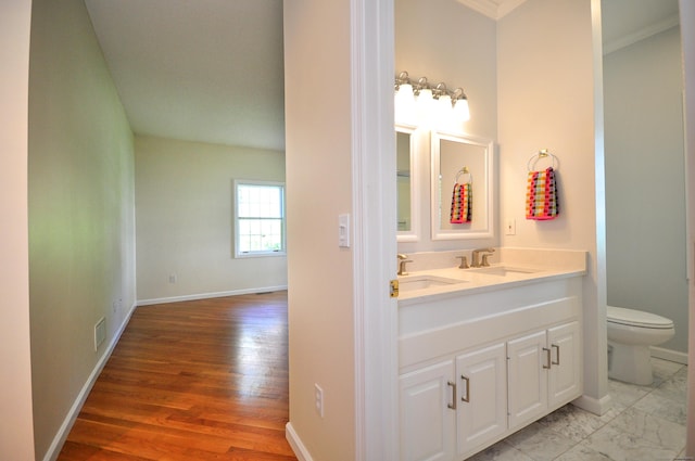 bathroom featuring a sink, baseboards, toilet, and visible vents