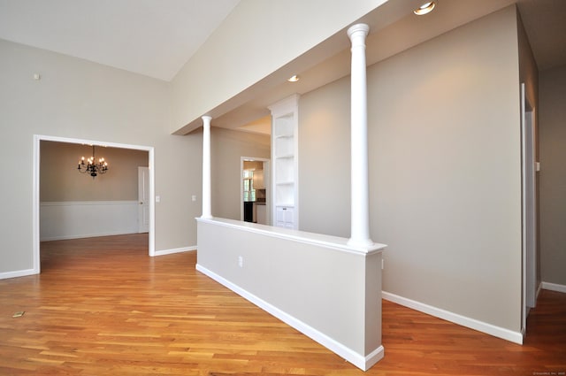 corridor featuring recessed lighting, baseboards, a notable chandelier, and light wood finished floors