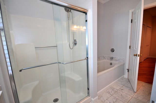 bathroom featuring marble finish floor, a shower stall, and a bath