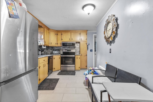 kitchen featuring crown molding, light tile patterned floors, decorative backsplash, and stainless steel appliances