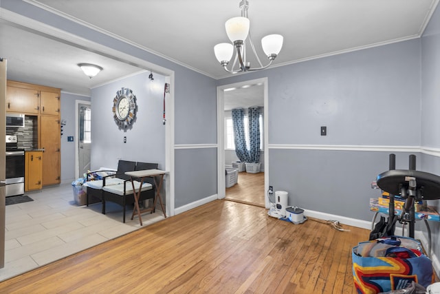 dining room featuring a notable chandelier, ornamental molding, and light wood-type flooring