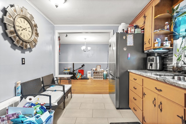 kitchen with stainless steel fridge, backsplash, ornamental molding, decorative light fixtures, and a chandelier