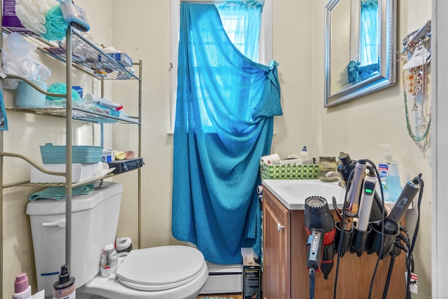 bathroom featuring vanity, baseboard heating, and toilet