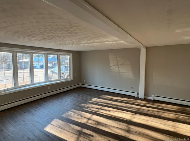 spare room featuring hardwood / wood-style flooring and baseboard heating