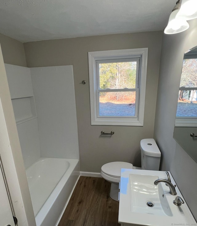 bathroom featuring sink, hardwood / wood-style flooring, toilet, and a bathtub