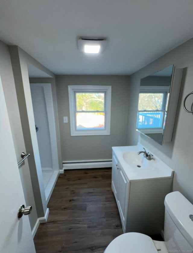 bathroom with vanity, toilet, a baseboard radiator, and wood-type flooring