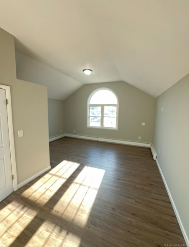 bonus room with dark hardwood / wood-style floors and vaulted ceiling