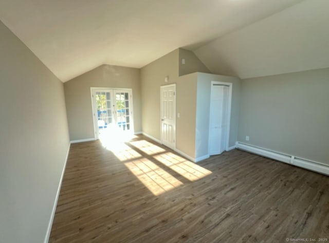 additional living space featuring a baseboard heating unit, dark hardwood / wood-style flooring, and vaulted ceiling