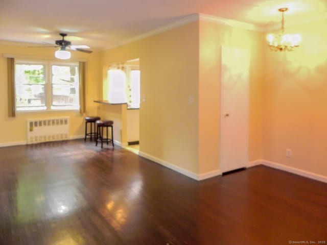 unfurnished room with crown molding, dark hardwood / wood-style floors, radiator, and ceiling fan with notable chandelier