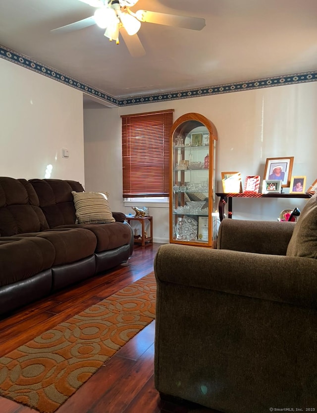 living room featuring ceiling fan and dark hardwood / wood-style floors