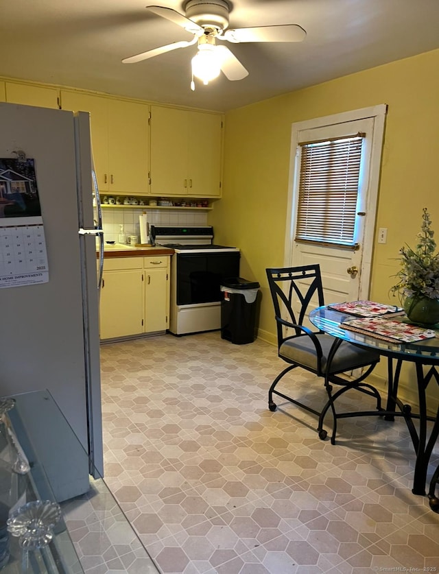 kitchen with decorative backsplash, ceiling fan, refrigerator, and range with electric cooktop