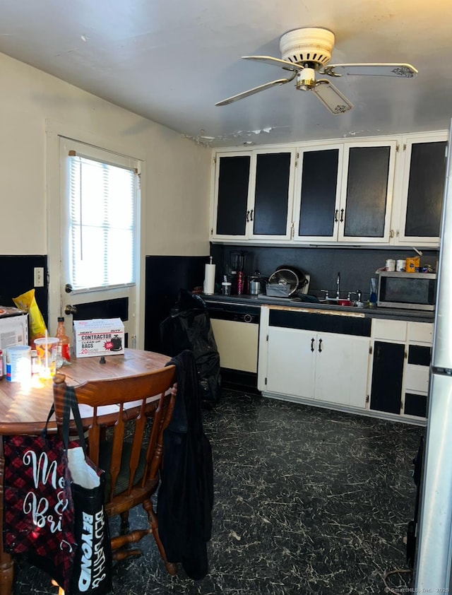 kitchen with sink, dishwasher, white cabinetry, and ceiling fan