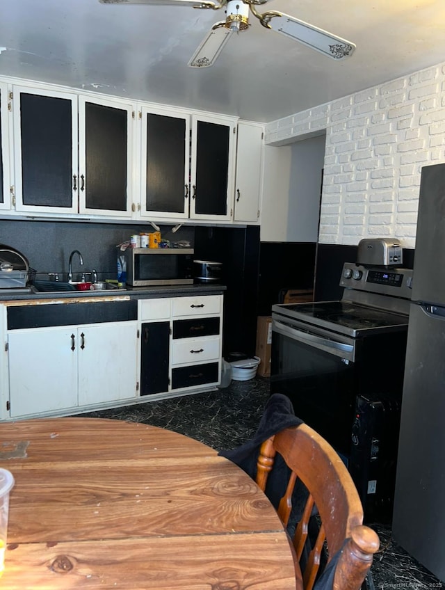 kitchen with white cabinets, stainless steel appliances, ceiling fan, and sink