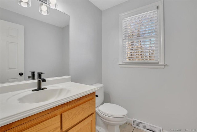 bathroom with vanity, a wealth of natural light, tile patterned floors, and toilet