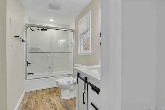 full bathroom with enclosed tub / shower combo, vanity, toilet, and wood-type flooring