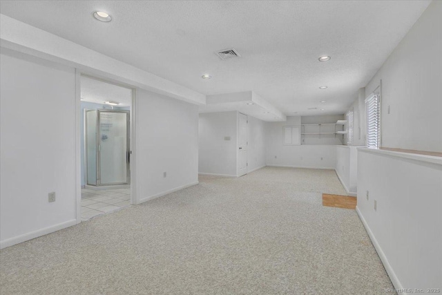 empty room featuring light colored carpet and a textured ceiling