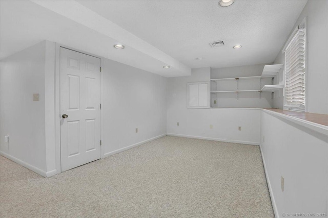 carpeted spare room with a textured ceiling