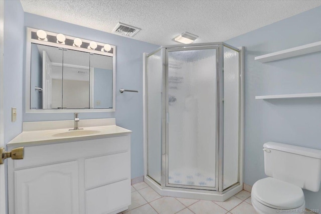 bathroom featuring tile patterned flooring, vanity, toilet, a shower with door, and a textured ceiling