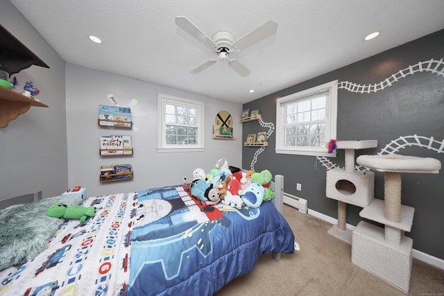 carpeted bedroom featuring ceiling fan and a baseboard heating unit