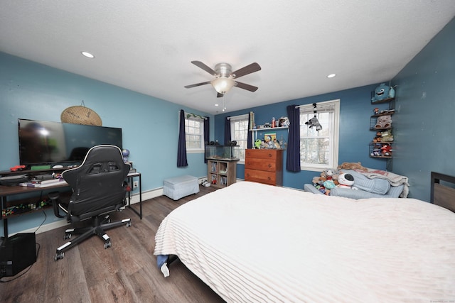 bedroom featuring hardwood / wood-style flooring, ceiling fan, a textured ceiling, and a baseboard heating unit