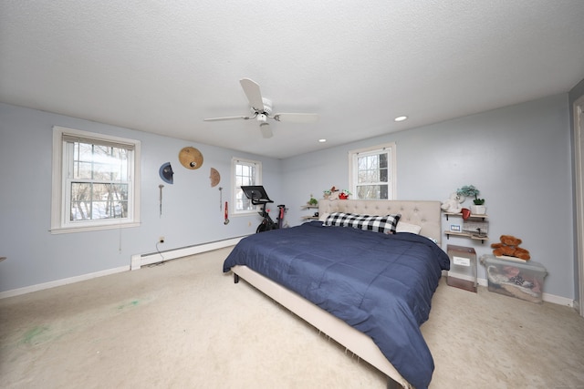 bedroom featuring carpet, a textured ceiling, a baseboard radiator, ceiling fan, and multiple windows