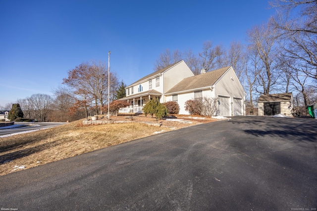 view of front of house with covered porch, driveway, and an attached garage