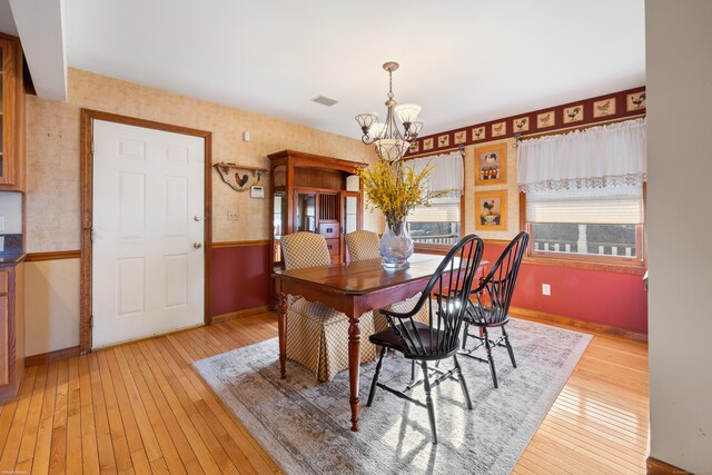 dining space with a chandelier and light wood-type flooring