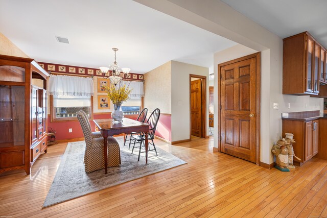 dining room featuring a notable chandelier and light wood-type flooring