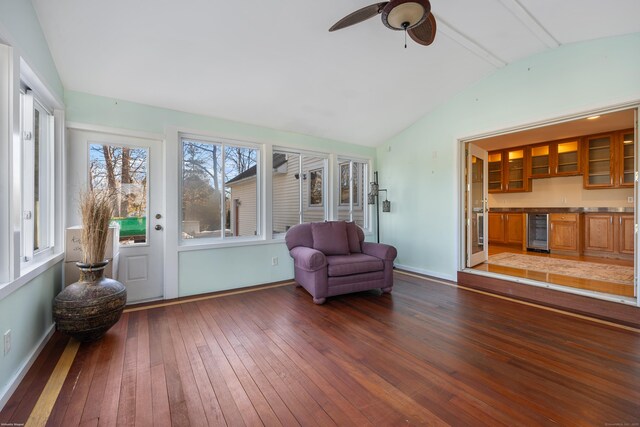 sunroom / solarium featuring wine cooler, ceiling fan, bar area, and vaulted ceiling