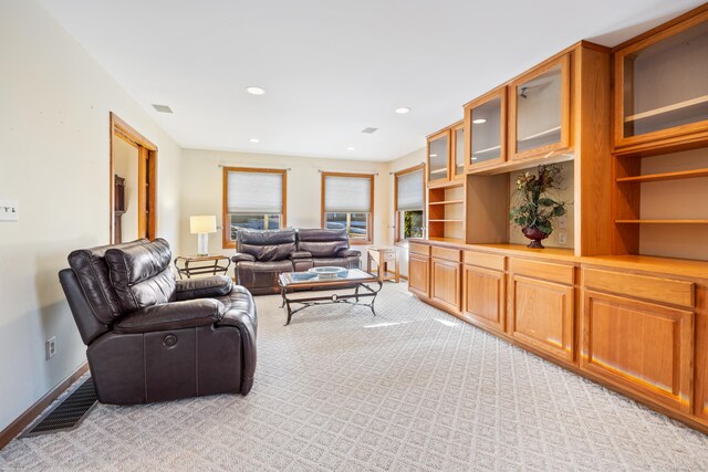 living room featuring baseboards, visible vents, and light colored carpet