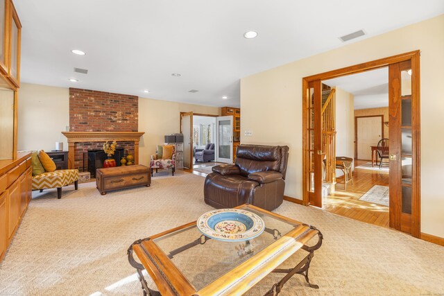 living room with light carpet and a brick fireplace