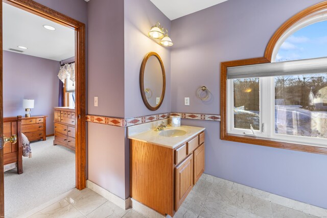 bathroom featuring marble finish floor, vanity, and recessed lighting