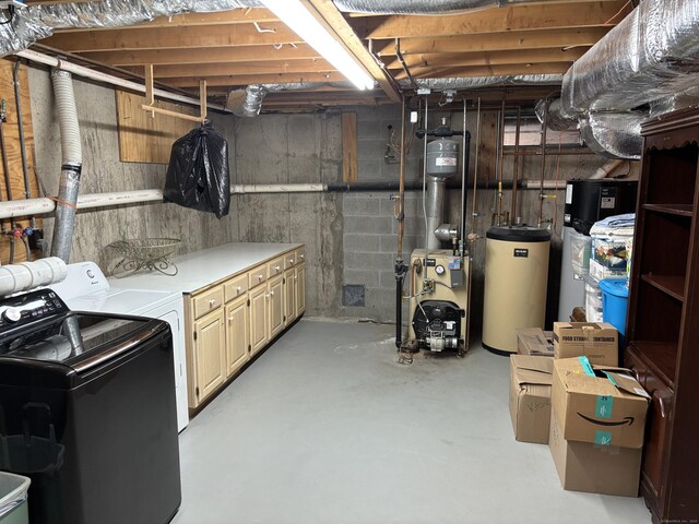 unfinished basement with water heater, a heating unit, and washing machine and dryer