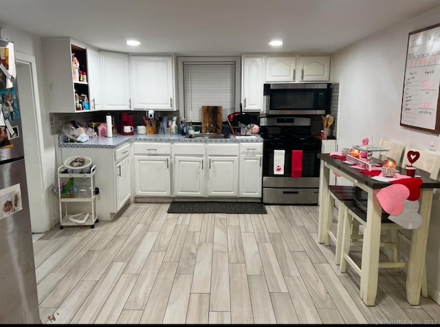 kitchen featuring white cabinetry, appliances with stainless steel finishes, and light wood-type flooring