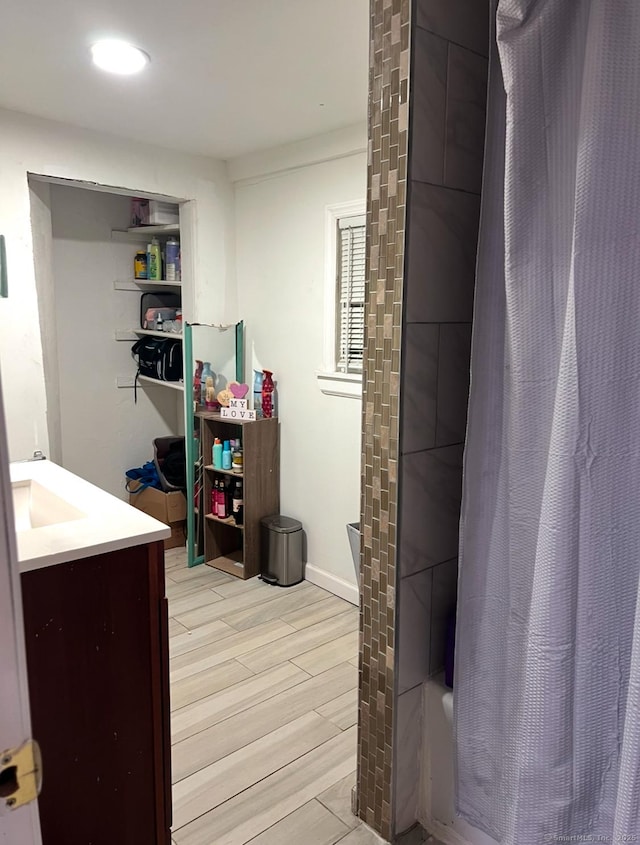 bathroom featuring vanity, hardwood / wood-style floors, and shower / bathtub combination with curtain