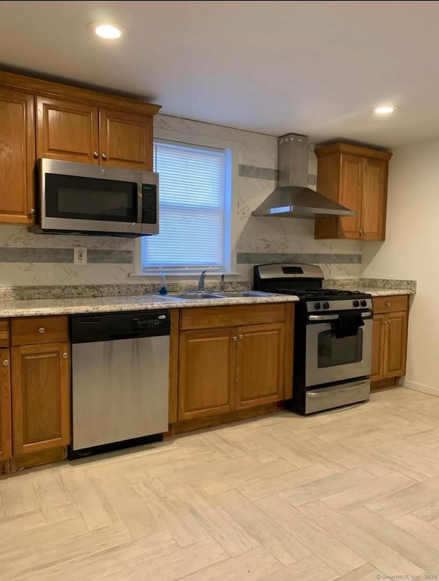 kitchen featuring wall chimney exhaust hood, appliances with stainless steel finishes, light parquet flooring, and sink