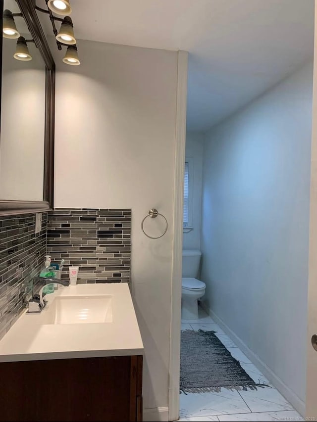 bathroom with toilet, tasteful backsplash, and vanity