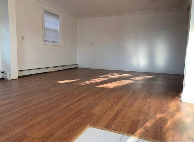 unfurnished room featuring ornamental molding, baseboard heating, and dark wood-type flooring