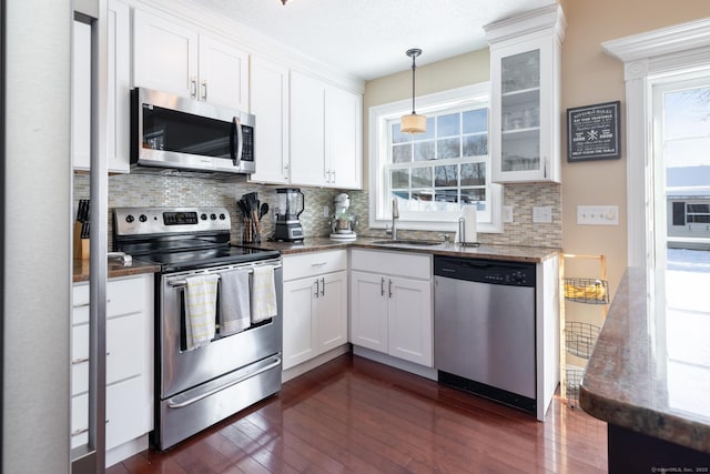 kitchen with stainless steel appliances, sink, decorative backsplash, and white cabinets