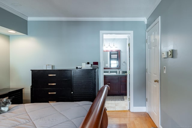 bedroom with light parquet floors, crown molding, and sink