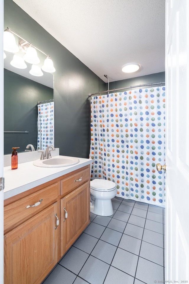 bathroom featuring tile patterned floors, toilet, a textured ceiling, and vanity