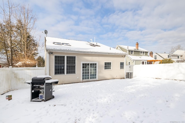 snow covered back of property with central air condition unit