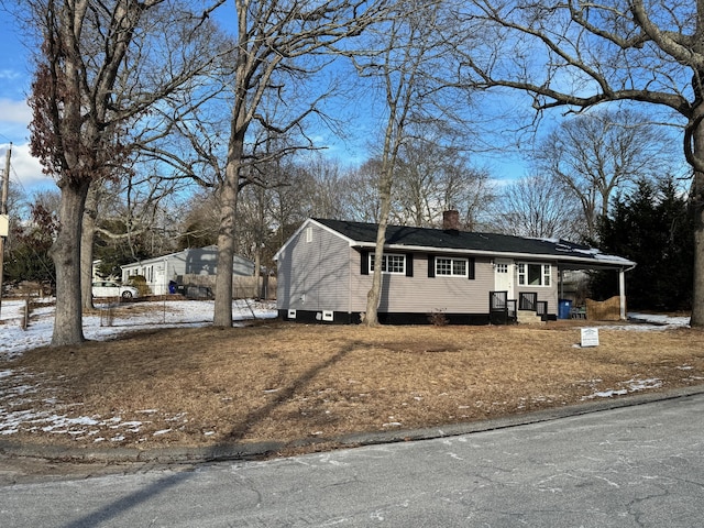 view of front of property with a carport and a chimney