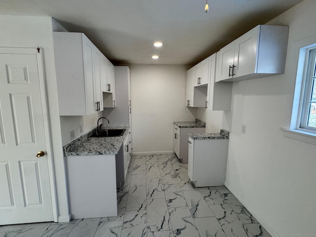 kitchen featuring white cabinetry, sink, and dark stone countertops