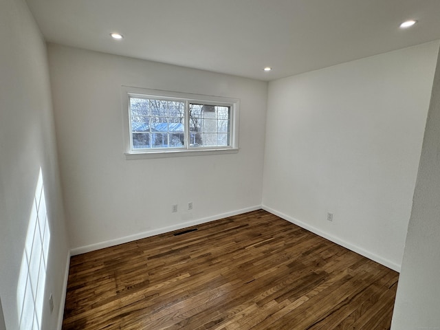 spare room with dark hardwood / wood-style flooring