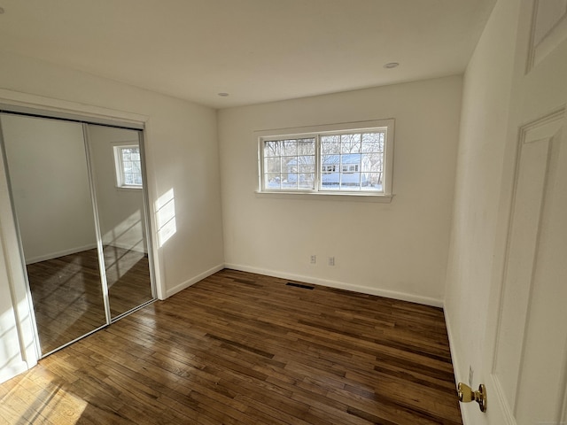 unfurnished bedroom featuring dark hardwood / wood-style floors and a closet