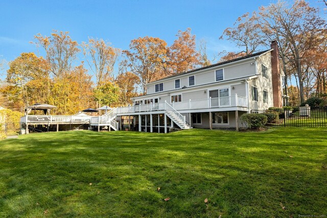 rear view of house with a yard and a deck