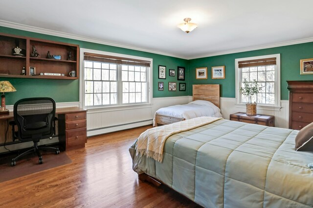 bedroom featuring hardwood / wood-style flooring, ornamental molding, and baseboard heating