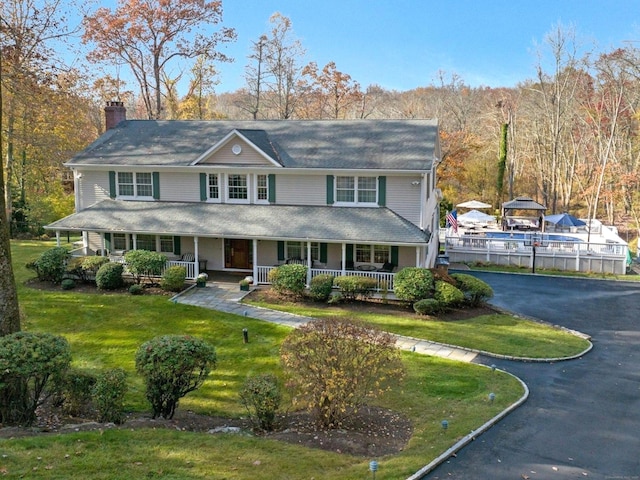 view of front of home featuring covered porch and a front lawn